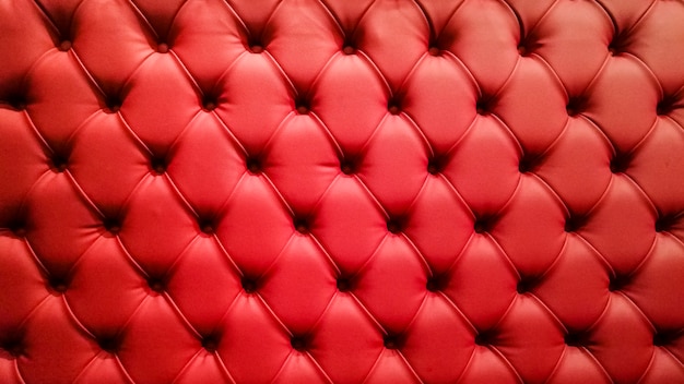 Czerwona pikowana sofa tło