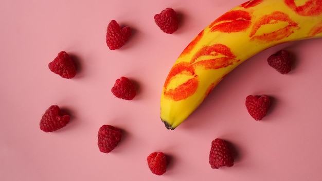 Czerwona Szminka Na żółtym Bananie Na Różowym Tle Z Bananowymi Malinami. Koncepcja Miłości. Premium Zdjęcia