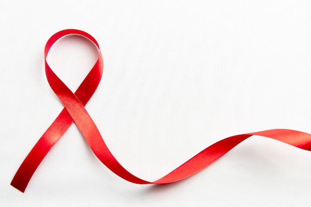Czerwona wstążka z białym tłem. Świadomość wstążki HIV Aids