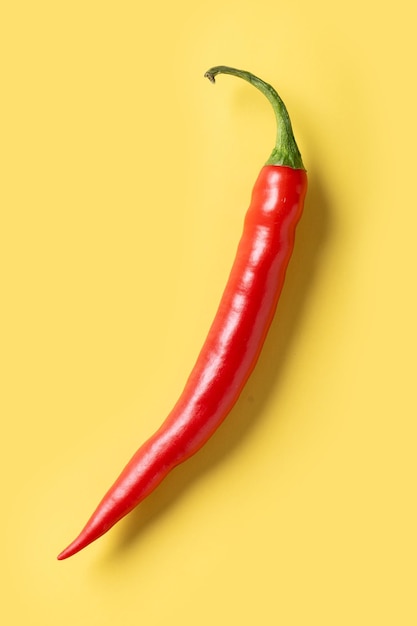 Bezpłatne zdjęcie czerwone gorące papryki chili na żółtym tle