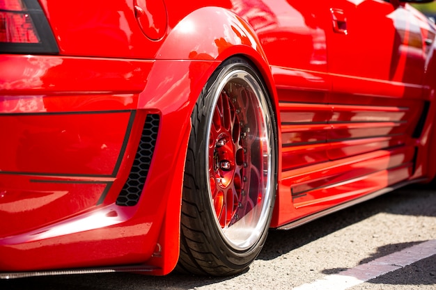 Czerwony sportowy tuningowany samochód widok z tyłu koła, zbliżenie
