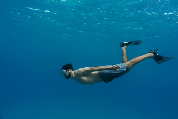 Bezpłatne zdjęcie człowiek freediving z płetwami pod wodą