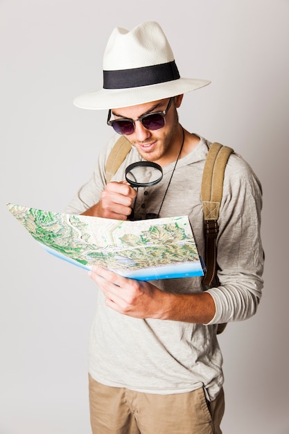 Człowiek Hipster przy użyciu lupy do czytania mapy