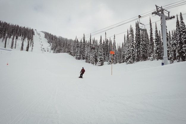 Bezpłatne zdjęcie człowiek na nartach na zaśnieżonych alpach w ośrodku narciarskim