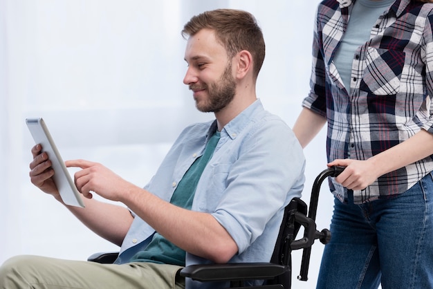 Człowiek na wózku inwalidzkim z tabletem