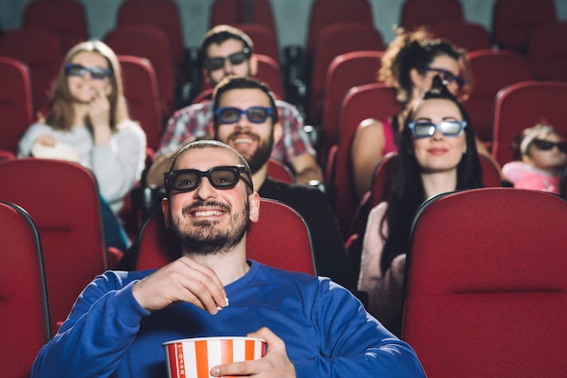 Człowiek ogląda film w pełnym kinie