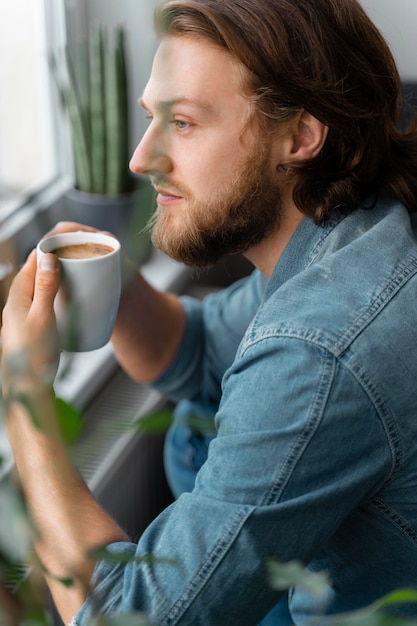 Bezpłatne zdjęcie człowiek posiadający filiżankę kawy z bliska