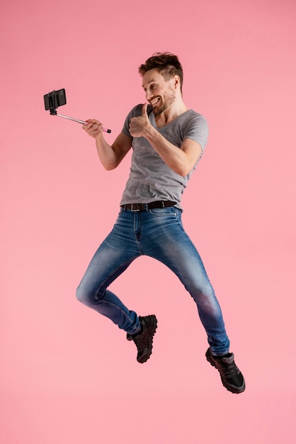Człowiek skaczący z kijem selfie