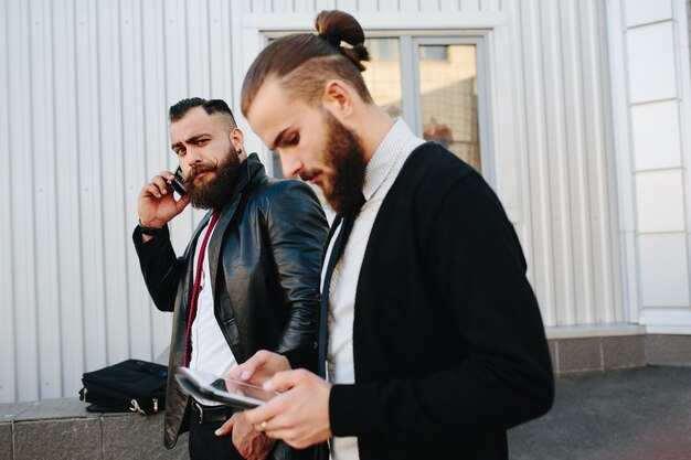 Człowiek sprawdzanie jedną tabletkę, a druga mówi przez telefon