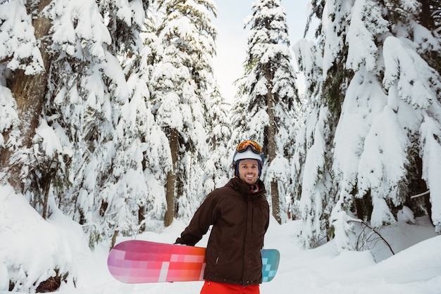 Bezpłatne zdjęcie człowiek stojący i trzymając snowboard