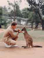 Bezpłatne zdjęcie człowiek w rezerwie bawi się kangurem