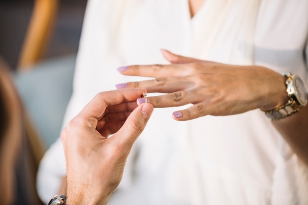 Człowiek wprowadzenie pierścionek zaręczynowy na palec jego narzeczony