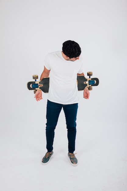 Bezpłatne zdjęcie człowiek z longboard za plecami