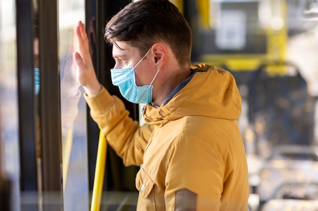 Bezpłatne zdjęcie człowiek z maską chirurgiczną w transporcie publicznym