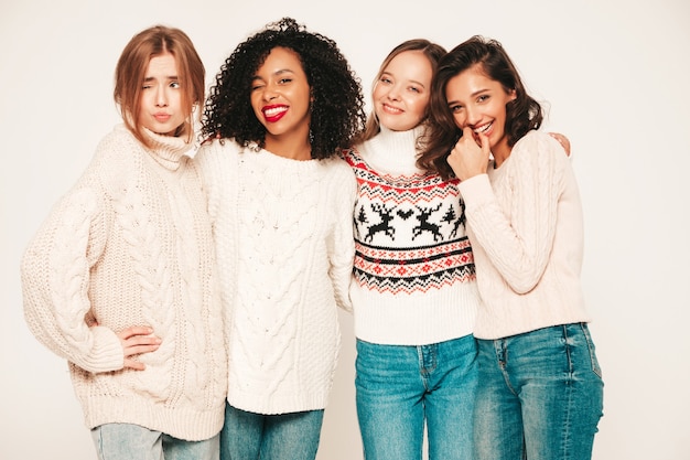 Cztery Młode Piękne Uśmiechnięte Hipster Dziewczyny W Modnych Zimowych Swetrach. Pozytywne Modele Bawiące Się I Przytulające