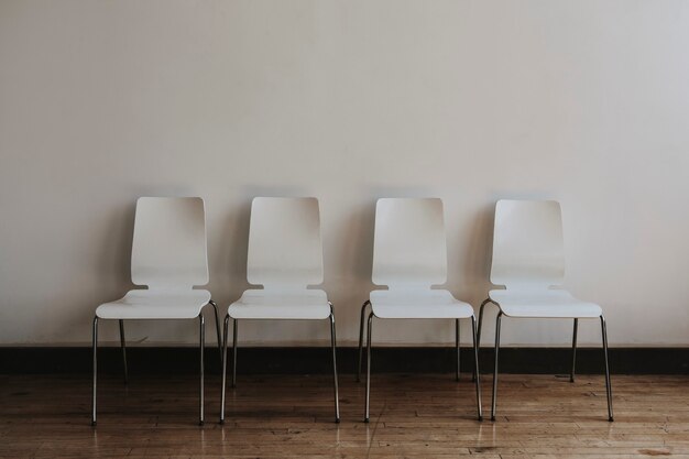 Cztery puste białe krzesła w pokoju
