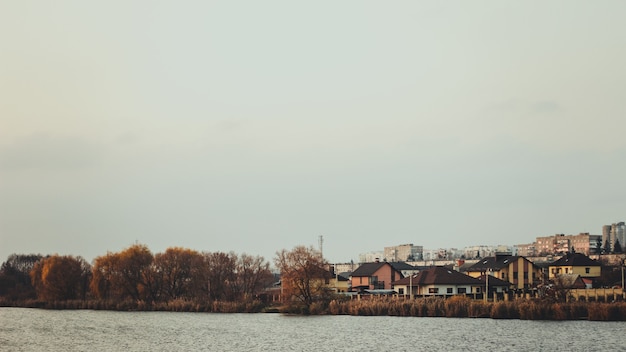 Czyste jezioro otoczone jesiennymi drzewami i domami