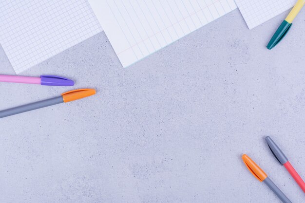 Czyste papiery i kolorowe ołówki na szaro.
