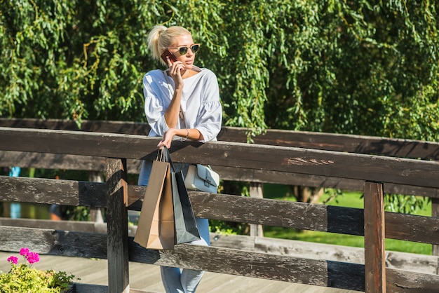 Dama opowiada na smartphone na footbridge