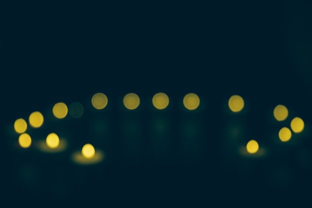 Bezpłatne zdjęcie defocused żółty bokeh na czarnym tle