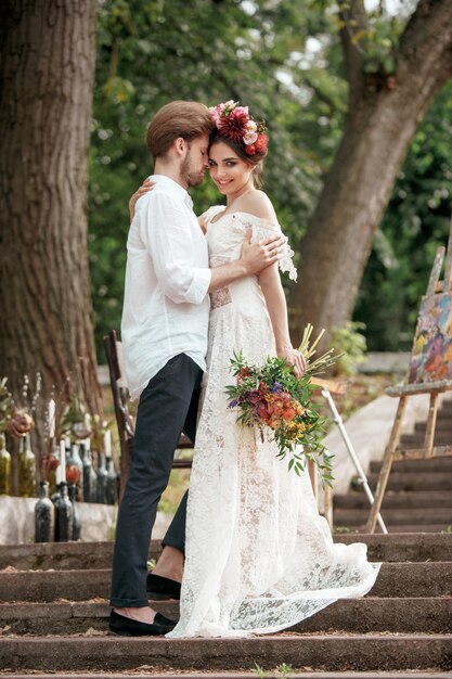 Dekoracja ślubna w stylu boho, kompozycja kwiatowa, zdobiony stół w ogrodzie.