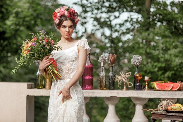 Dekoracja ślubna w stylu boho, kompozycja kwiatowa, zdobiony stół w ogrodzie.