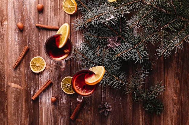Bezpłatne zdjęcie dekoracje świąteczne i noworoczne. dwie szklanki grzanego wina z pomarańczami