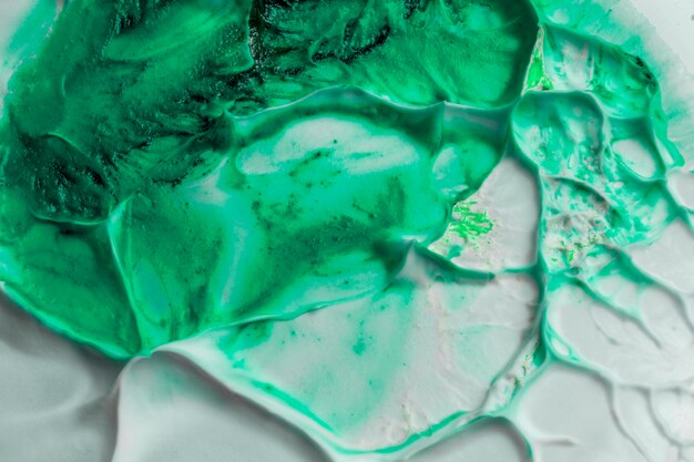 Dekoracyjna zielona mieszanka farby nad białą teksturowaną powierzchnią