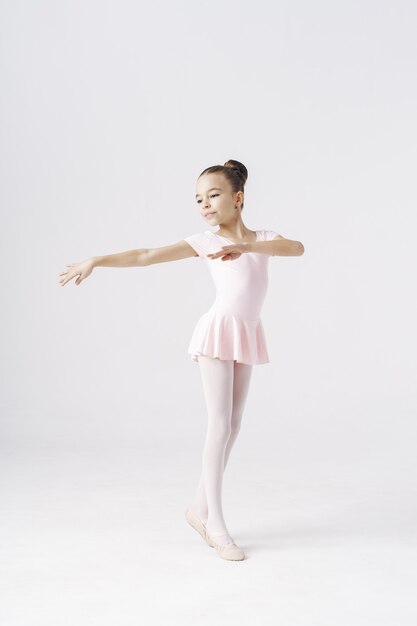 Delikatna dziewczyna baleriny stojący w pozie baletowej na białym. Rodzaje koncepcji rozwoju osobowości.