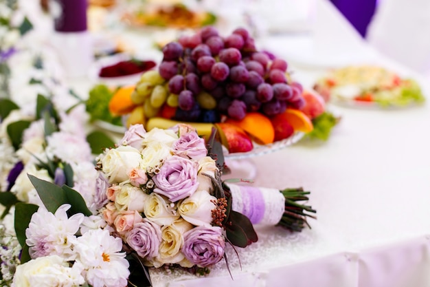 Delikatny bukiet ślubny wykonany z beżowych i fioletowych róż