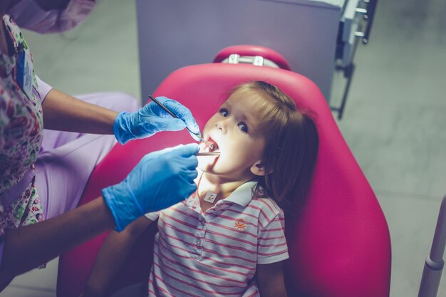 dentysta dziecięcy. Mała dziewczynka przy przyjęciem przy dentystą.