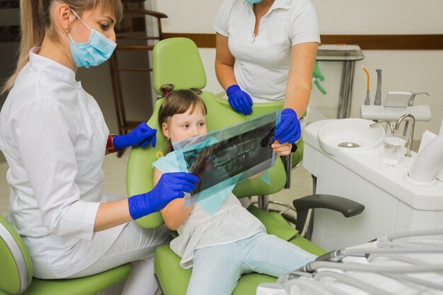 Dentysta i dziewczynka pacjenta patrząc na radiografii