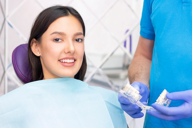 Dentysta i pacjent w gabinecie stomatologicznym. kobieta mająca zęby zbadane przez dentystów