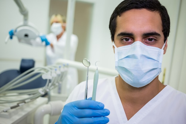 Dentysta trzyma stomatologicznych narzędzia w stomatologicznej klinice
