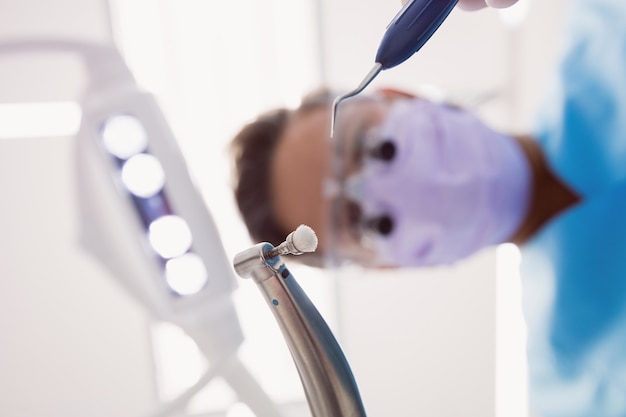 Bezpłatne zdjęcie dentysta trzyma stomatologicznych narzędzia