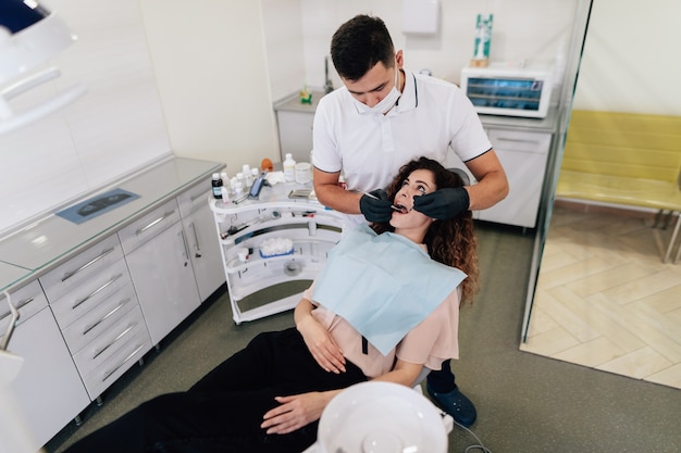 Dentysta wykonuje badanie kontrolne na kobiecie