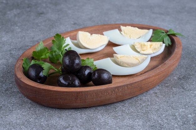 Deska drewniana z oliwkami i jajkami na twardo. Wysokiej jakości zdjęcie