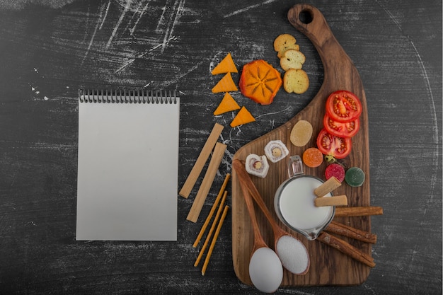 Deska z przekąskami z krakersami i warzywami z książką kucharską