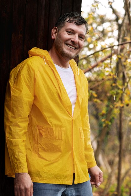 Deszcz portret młodego mężczyzny w płaszczu przeciwdeszczowym