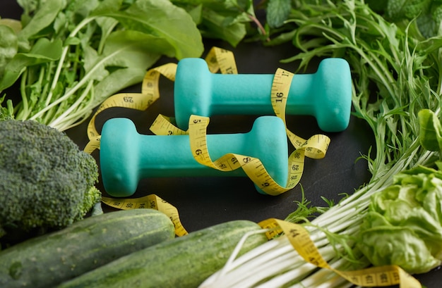 Dieta treningowa i fitness. Zdrowe jedzenie czyste wybór jedzenia z owoców, warzyw, hantle. Wybór koncepcji zdrowej żywności.