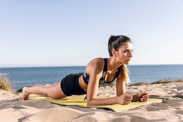 Długie ujęcie kobieta zaszaluje na macie fitness