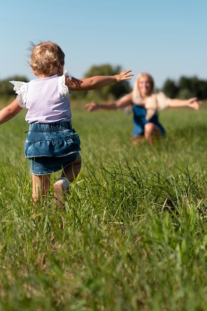 Długie ujęcie małej dziewczynki biegnącej do matki