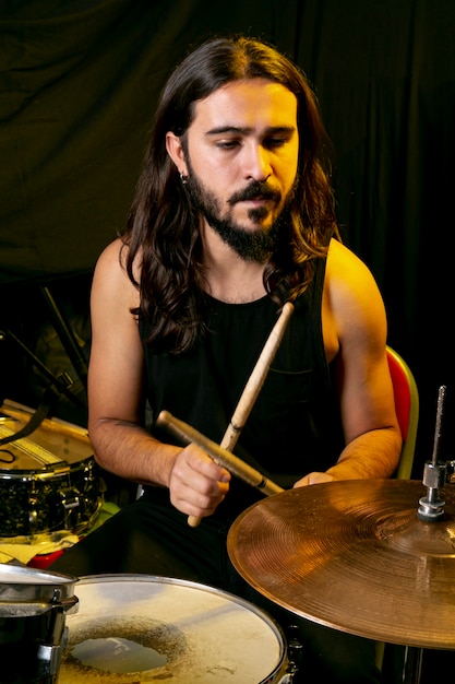 Długie włosy mężczyzna gra na perkusji
