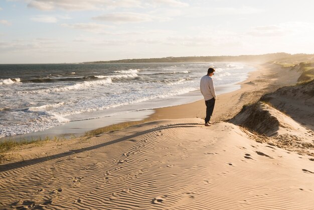 Długonogi człowiek idący na plaży