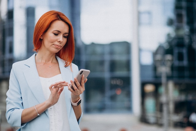 Dojrzała biznesowa kobieta opowiada na telefonie