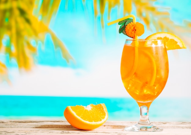 Dojrzała pomarańcza w plasterkach i szklanka soczystego napoju cytrusowego
