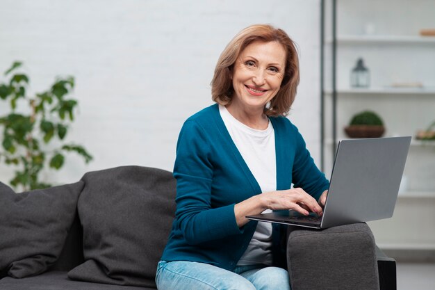 Dojrzała smiley kobieta używa laptop