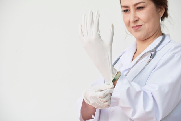 Dojrzały lekarz rodzinny zakłada rękawiczki