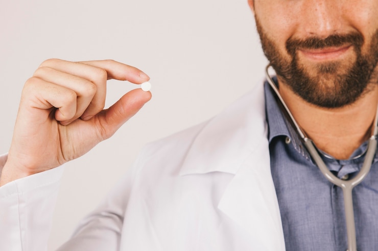 Bezpłatny plik Zdjęcie doktor uśmiecha się i trzyma pigułkę