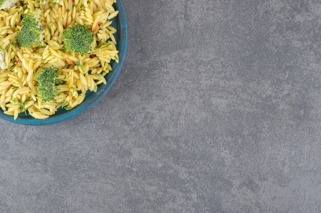 Domowy ryż z brokułami na niebieskim talerzu. Zdjęcie wysokiej jakości